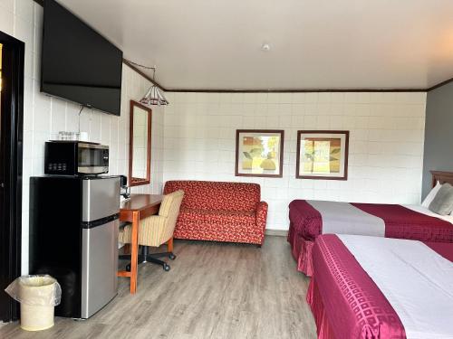 a hotel room with two beds and a desk with a microwave at Skyview Motel - Prairie du Sac in Prairie du Sac
