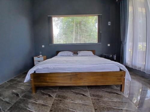 a bedroom with a large bed with a window at The Mandalika Rinjani Lombok in Masbagik