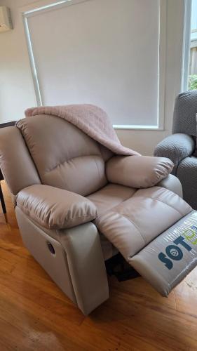 a leather couch with a blanket on top of it at Northshore Central Cosy & Comfortable 3BR Home in Auckland