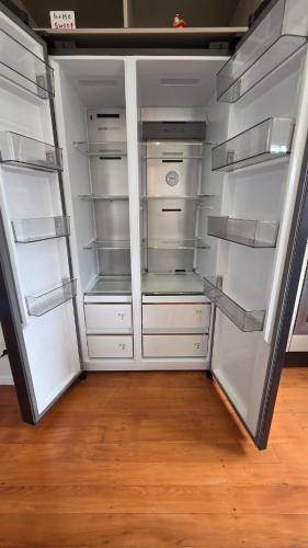a white refrigerator with its doors open in a room at Northshore Central Cosy & Comfortable 3BR Home in Auckland