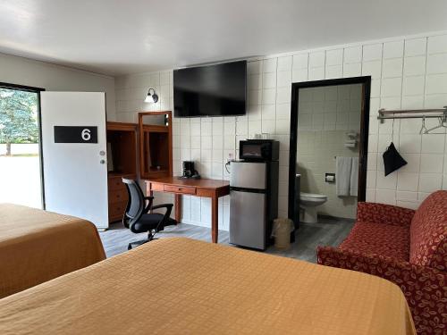 a hotel room with a bed and a desk and a kitchen at Skyview Motel - Prairie du Sac in Prairie du Sac