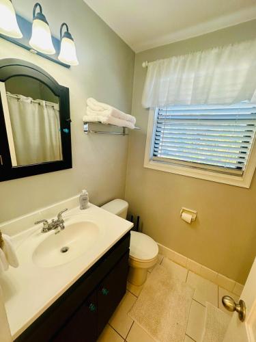 a bathroom with a sink and a toilet and a window at St Pete Beach in St. Pete Beach