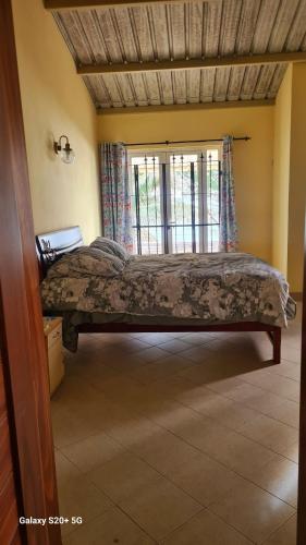 a bed in a room with a window at Jugroop beach house in Baie du Tombeau