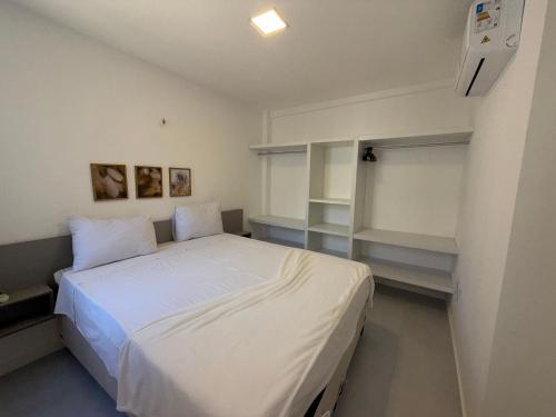 a bedroom with a white bed in a room at Hosts BR - Apartamentos funcionais in Fortaleza