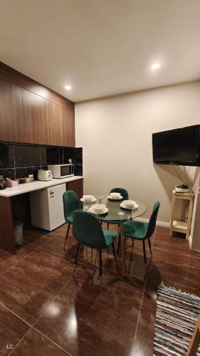 a room with a table and chairs and a kitchen at Private Modern 2 bedroom Unit in Central Albany in Auckland