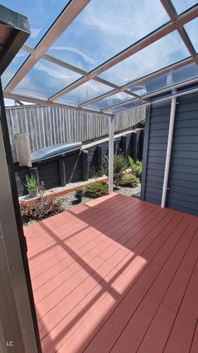 a wooden deck with a pergola on a house at Private Modern 2 bedroom Unit in Central Albany in Auckland