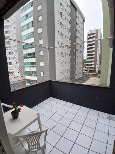 a balcony with a table and chairs and buildings at Cobertura próximo a Oktoberfest! in Blumenau