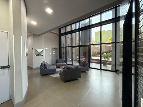 a living room with couches and a large window at Studio Soberano - O mais luxuoso de CG in Campo Grande