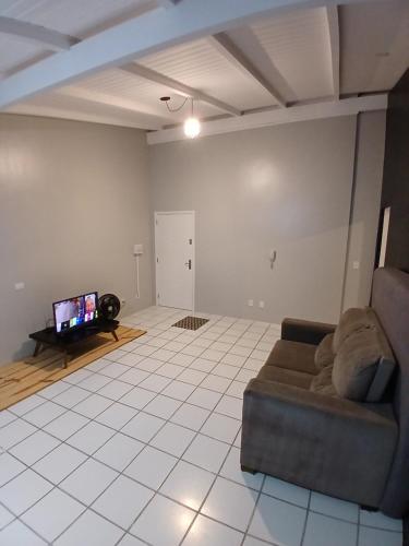 a living room with a couch and a flat screen tv at Cobertura próximo a Oktoberfest! in Blumenau