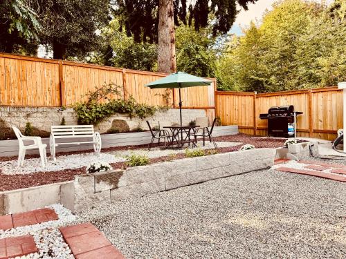 a patio with a table and an umbrella and a grill at 1 Bedroom Mini Apartment 10 Minutes to SeaTac Airport 1 Minute Walk to Bus Station in Seattle
