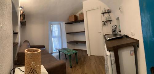 a small living room with a couch and a kitchen at Casa Delfino in Sanremo