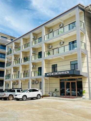 a large building with cars parked in front of it at Times Mansion Hotel Queen Room in Freetown