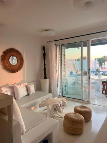 a living room with white furniture and a view of the ocean at Sunset Deluxe Villa and Studios in Paphos