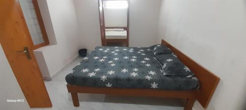 a small bed with a black and white comforter at Mahadev Residency in Tiruvannāmalai
