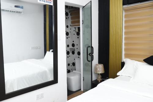 a bedroom with two beds and a mirror at Olabanji Royal Garden Hotel in Ibadan