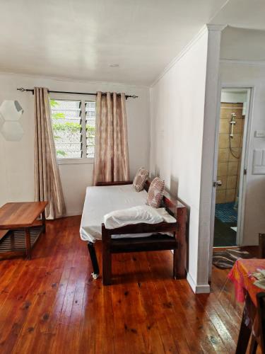 ein Schlafzimmer mit Bett, Fenster und Holzboden in der Unterkunft ACAs HAVEN in Suva