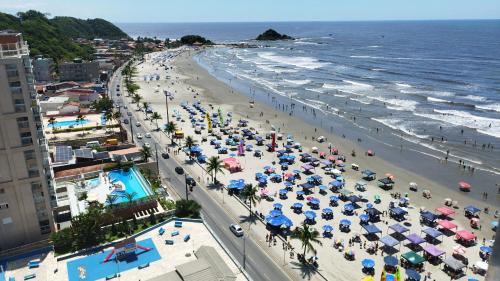 a beach with a lot of people and umbrellas at Frente para Mar de água cristalinas in Itanhaém