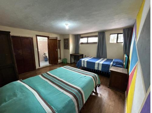 a bedroom with two beds in a room at Hostel Casa De Yagil in San Cristóbal de Las Casas