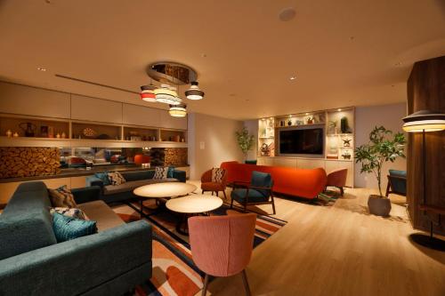a living room with couches and chairs and tables at Holiday Inn & Suites Sapporo Odori Park by IHG in Sapporo