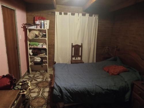 Un dormitorio con una cama y una estantería. en Cabañas La Quiverco, en Balneario Pehuén-Có