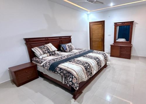 a bedroom with a bed and two night stands at Pearl Signature Farm House in Islamabad