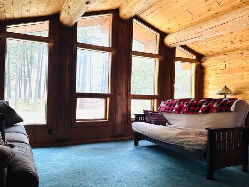 a living room with a couch in a room with windows at Living Well Lodge with Panoramic Views in Moyie Springs