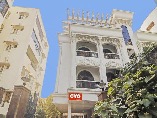 a white building with a sign in front of it at Super Hotel O Alpine Glow Crest in Hyderabad