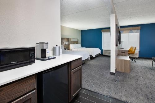 a large hotel room with a bed and a kitchen at Holiday Inn Express & Suites Eden Prairie - Minneapolis by IHG in Eden Prairie