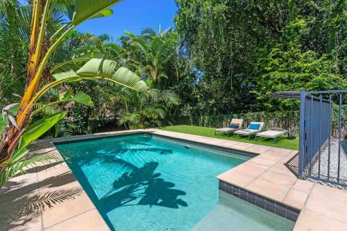 a swimming pool in a yard with two chairs at Large Family Pool Home in Taringa 6km to CBD Pets in Brisbane