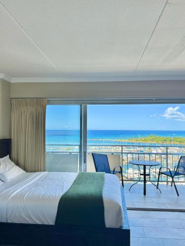 a bedroom with a bed and a view of the ocean at Panoramic Oceanview Resort - Full Kitchen in Each Unit, 2 Swimming Pools, Onsite Restaurants, Fireworks Every Friday in Honolulu