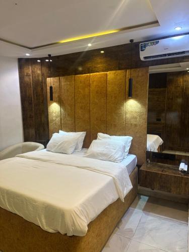 a bedroom with a large white bed and a tub at The Residence Hotel And Suites in Benin City