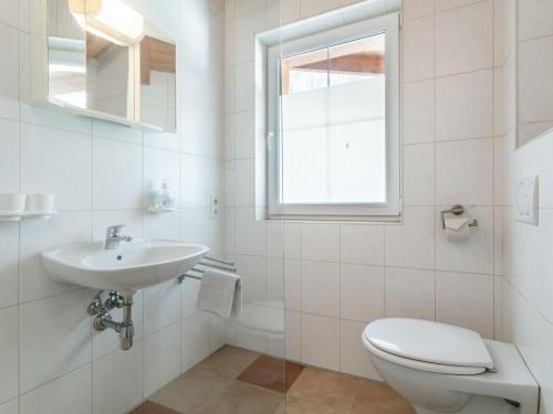 a white bathroom with a toilet and a sink at Haus Oliver 1 in Winkle