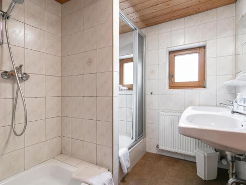 a bathroom with a tub shower and a sink at Haus Joachim in Winkle