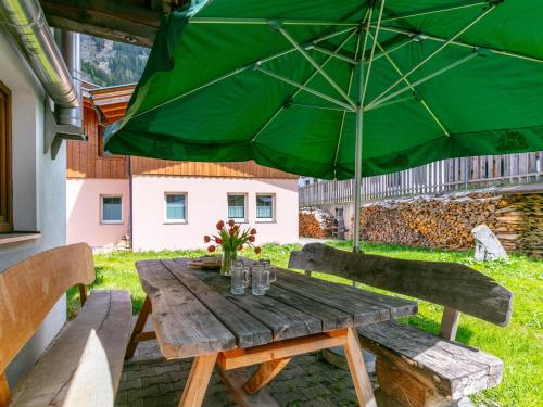 a wooden table with a green umbrella on a patio at Haus Joachim in Winkle