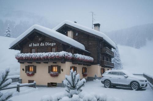 a car parked in front of a building in the snow at Bait da Diego in Livigno