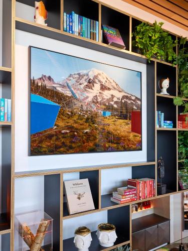 a flat screen tv on a wall in a library at citizenM Seattle Pioneer Square in Seattle