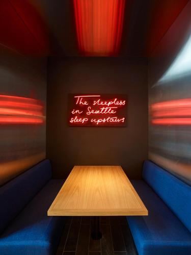 a table in a restaurant with a sign on the wall at citizenM Seattle Pioneer Square in Seattle