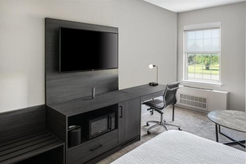 a room with a desk with a television and a chair at Holiday Inn Express St. Albans by IHG in Saint Albans