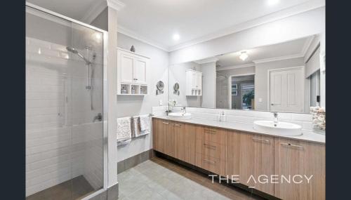 a large bathroom with two sinks and a shower at Luxury Hamptons Beach House in Kinross