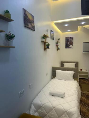 a white bed in a room with plants on the walls at Studio cozy 04 in Tangier