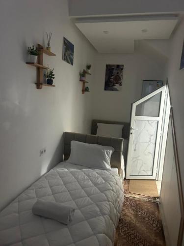a small bedroom with a bed and a mirror at Studio cozy 04 in Tangier