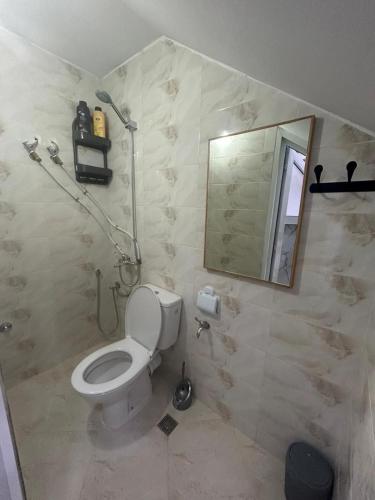 a bathroom with a toilet and a mirror at Studio cozy 04 in Tangier