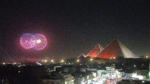 a firework display in front of the pyramids at night at pyramids view suite/vista piramidi in Cairo