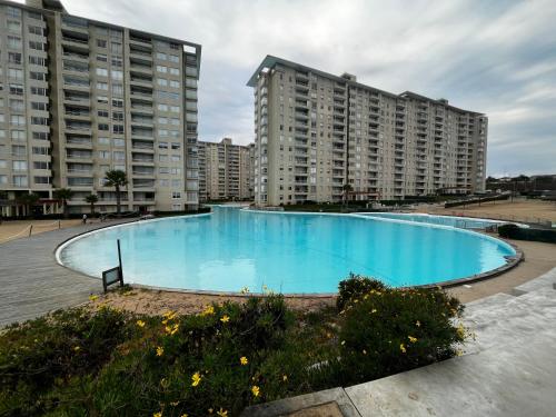 a large swimming pool in front of two tall buildings at Disfruta en Familia! in Algarrobo