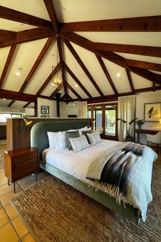 a bedroom with a large bed in a room with wooden ceilings at The Pavilion Yarra Valley luxury country retreat in Coldstream