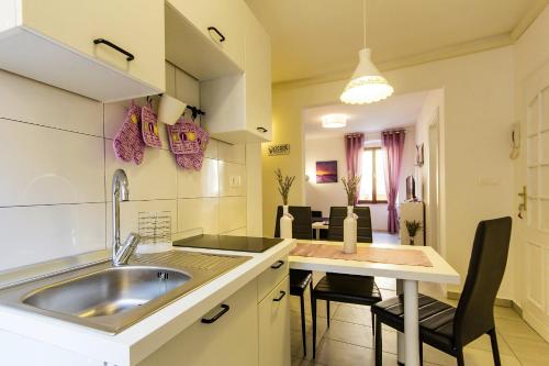 a kitchen with a sink and a table with chairs at Center Apartment Lori in Pula