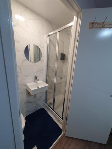 a bathroom with a shower and a sink at AMH Hotel - Greenford Station in Northolt