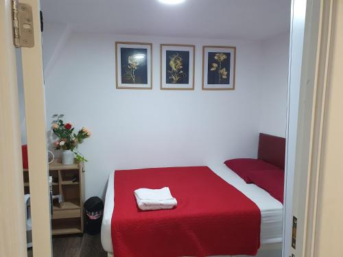 a room with a bed with a red blanket at AMH Hotel - Greenford Station in Northolt