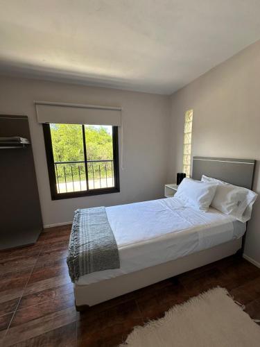 a bedroom with a large bed and a window at ALMAS CASAS de SIERRAS in San Lorenzo