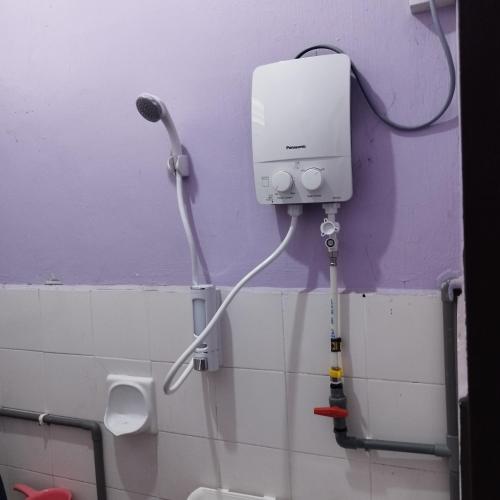 a bathroom with a hair dryer attached to a wall at Mastermind Malay Semeling Homestay in Bedung